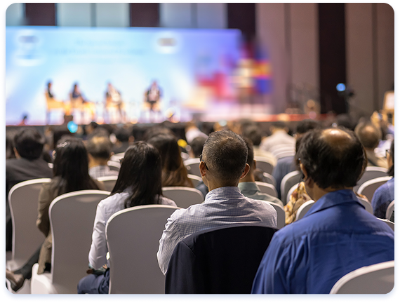 A group of conference attendees sitting in a conference room during a Q&A panel