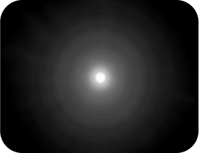 Zwarte achtergrond met een fel licht in het midden, omgeven door een halo die groter is dan die van de Clareon Monofocale en Clareon Vivity IOL's, wat de optische bench halo-meting voor de TECNIS Synergy IOL vertegenwoordigt.