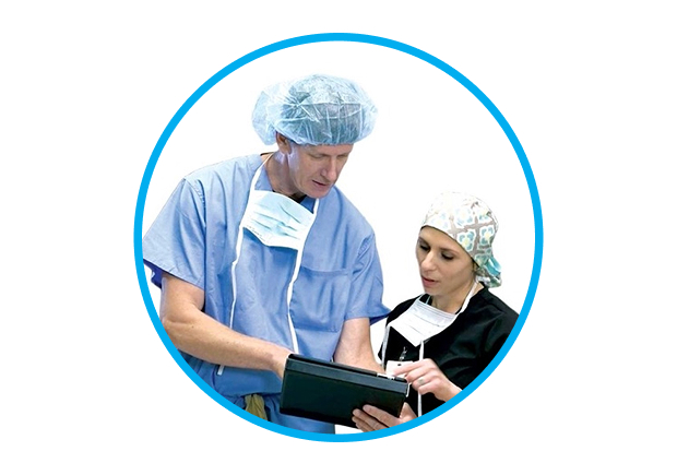Een afbeelding van een man en een vrouw in operatiekleding die communiceren met een tablet.