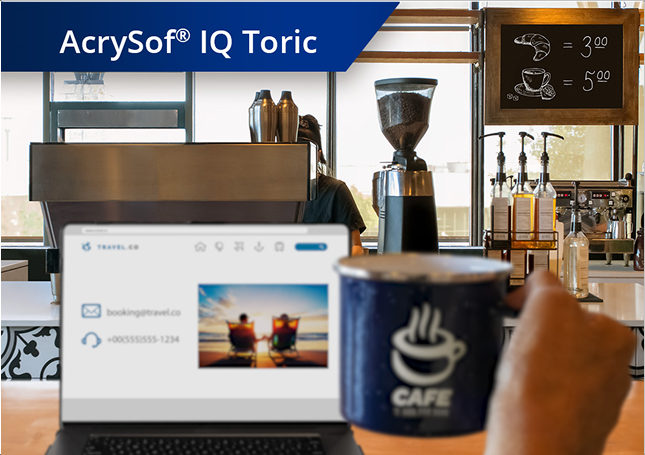 Duidelijk beeld van een koffiewinkel met zicht vanaf de toonbank op koffiemachines en andere ingrediënten. Een laptop staat open op het aanrecht en iemands hand houdt een koffiemok omhoog rechts van het laptopscherm. Witte tekst in de linkerbovenhoek van deze afbeelding luidt "AcrySof IQ PanOptix."