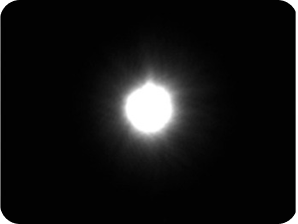 Zwarte achtergrond met een helder licht in het midden voor de halometing van de optical bench voor AcrySof® IQ monofocale IOL. 