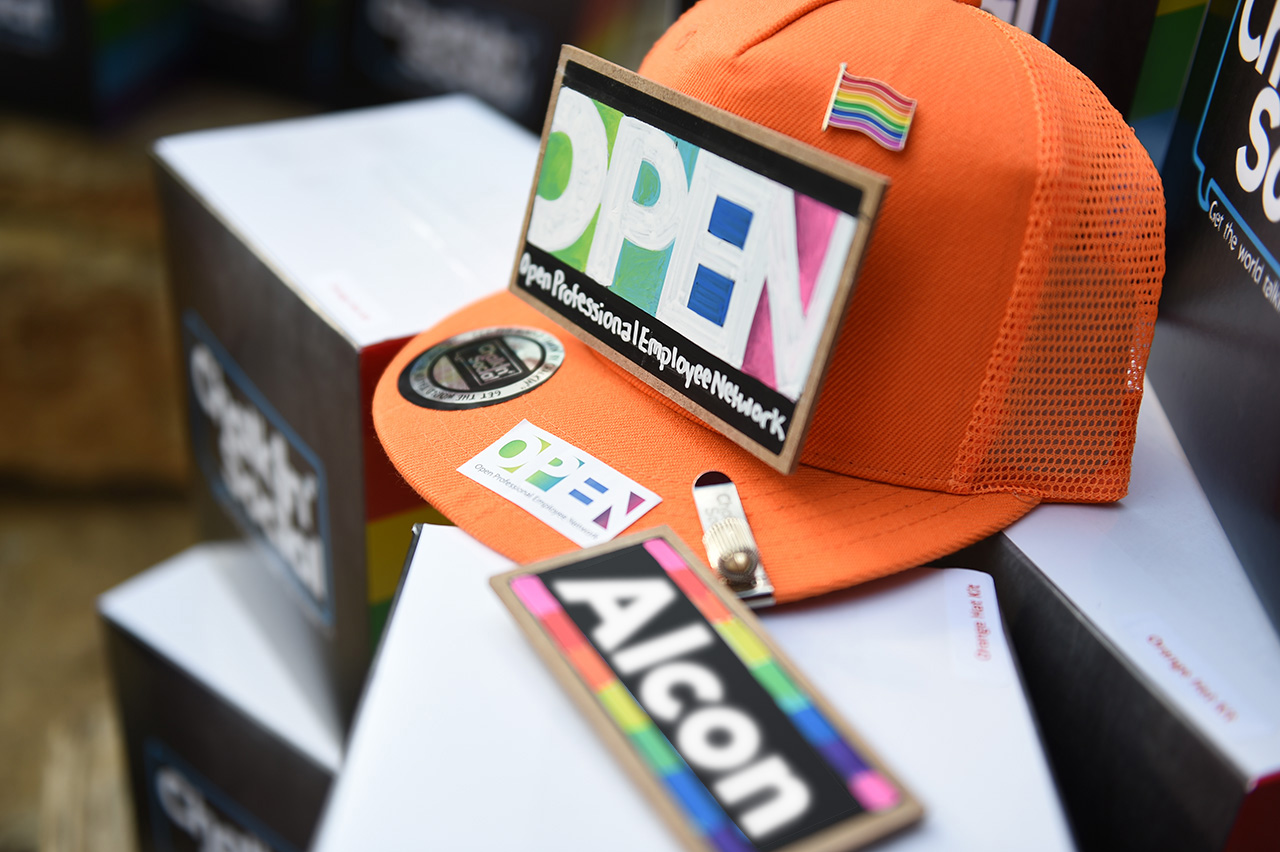 Close-up of ball cap with OPEN logos and Pride flag pin