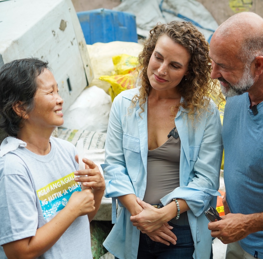 Two people talking to a woman at a Plastic Bank in the Phillippines