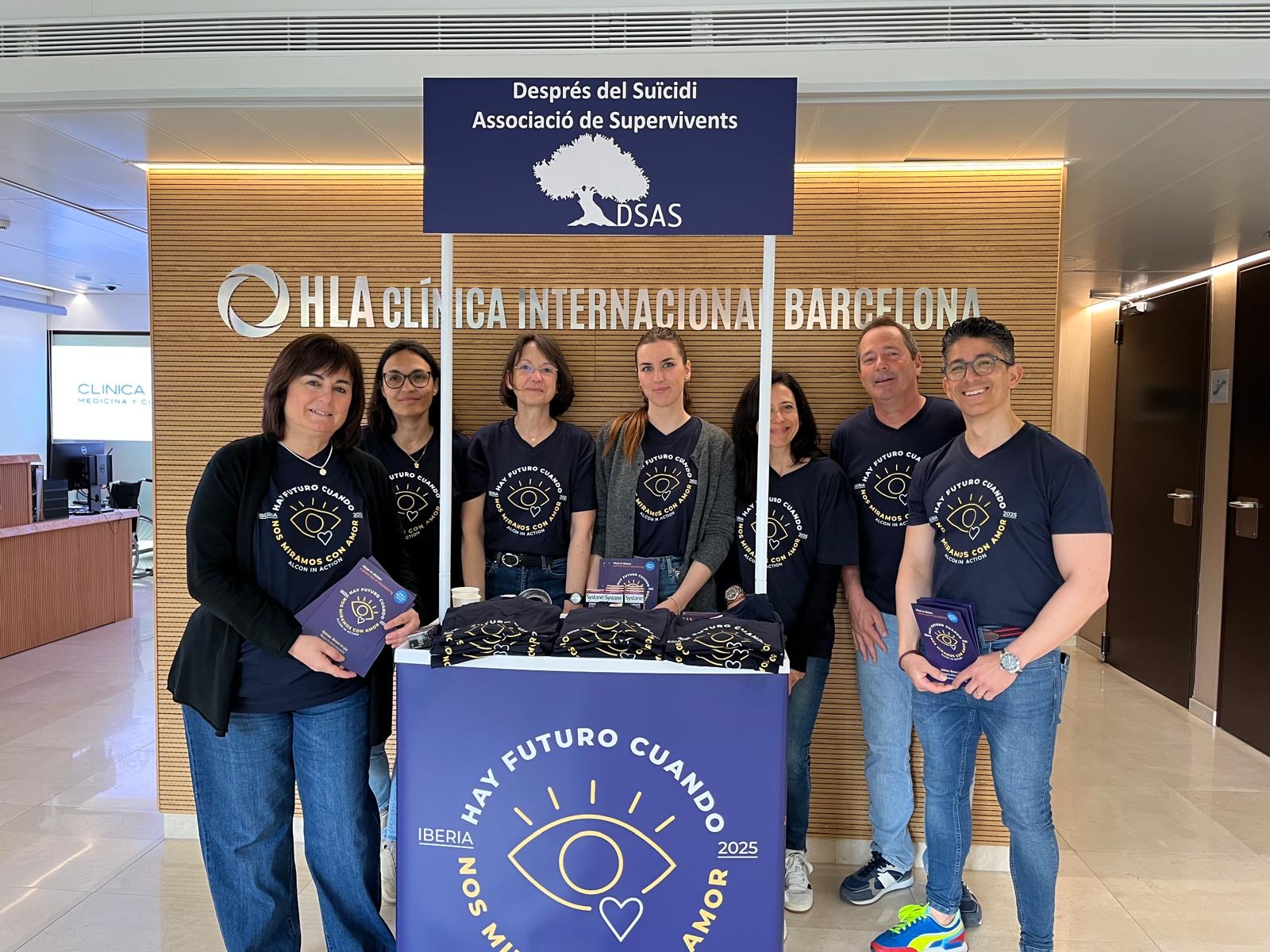 Group of Alcon employees, wearing matching t-shirts for a mental health organization, standing at a booth