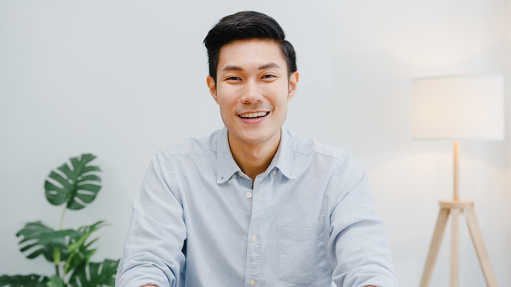 A young Asian man smiling at the camera.