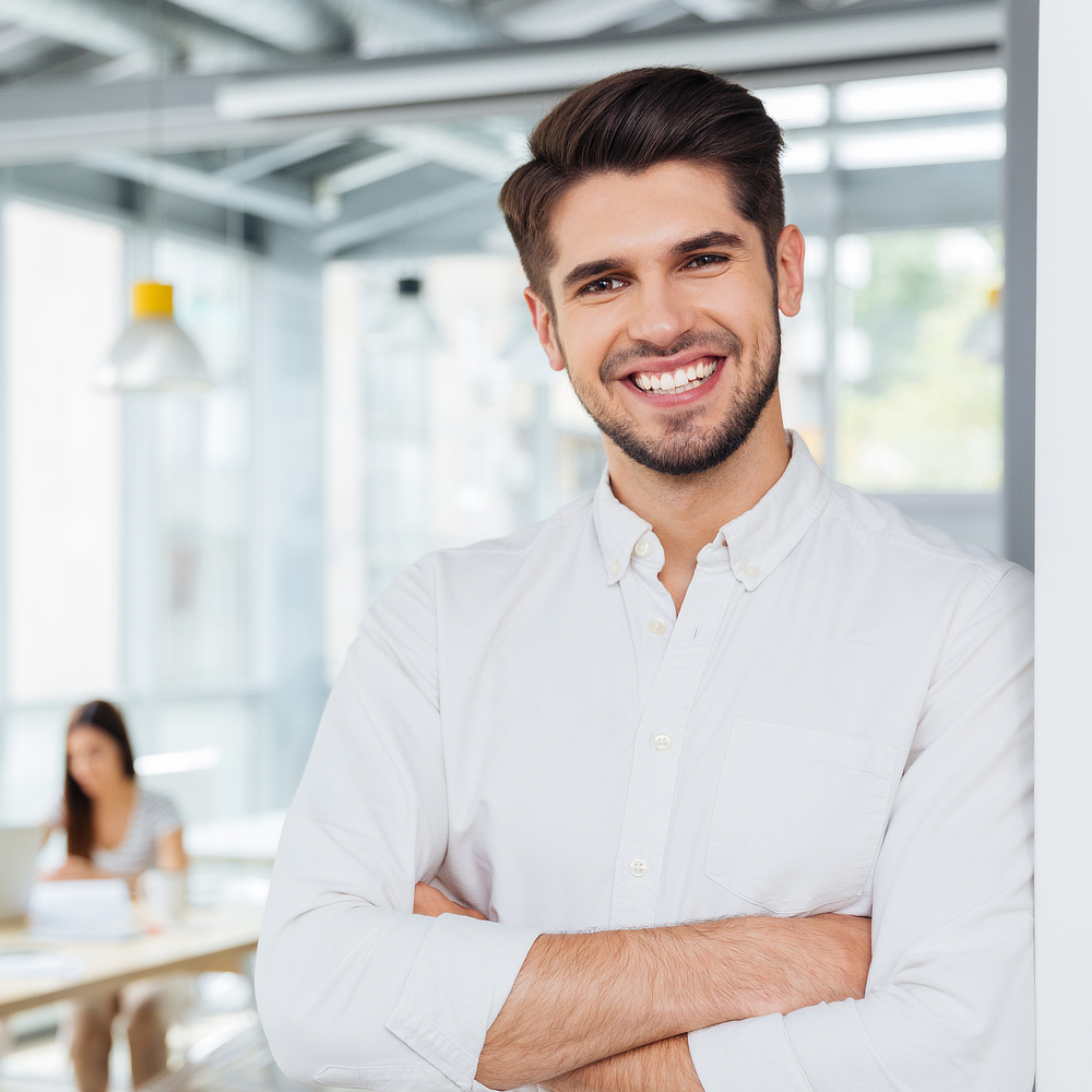 Bearded young man smiling at the camera.