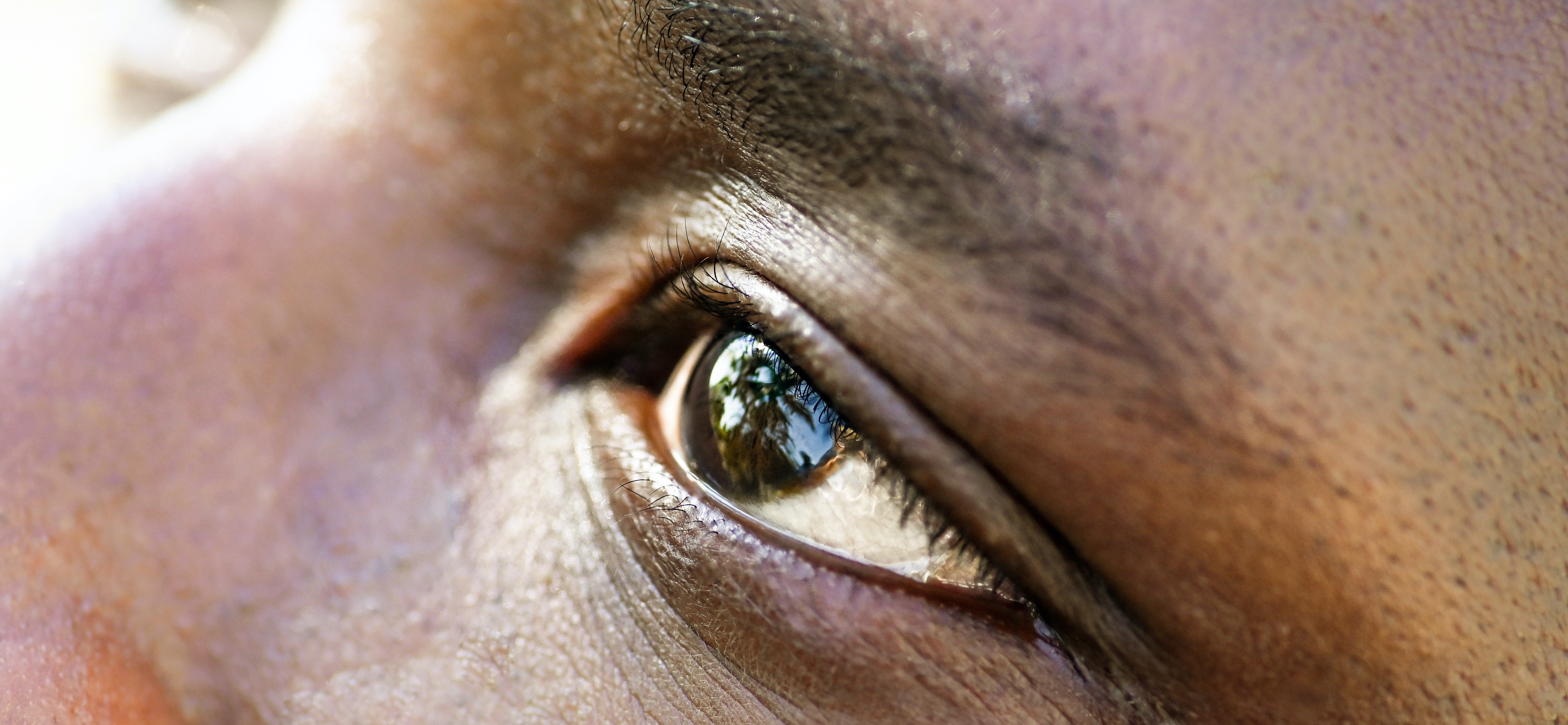 Close-up of a man's eye, as he looks up and to the left.