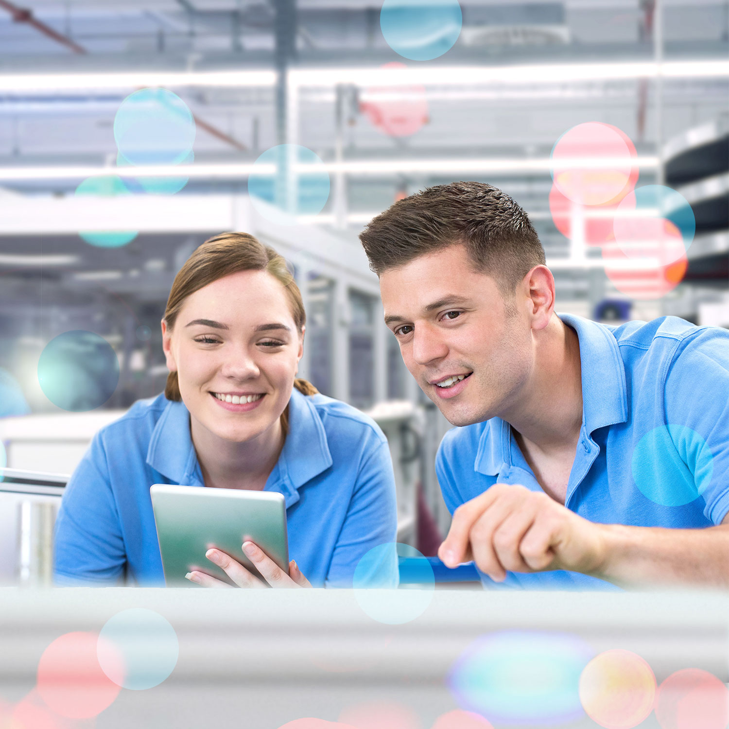 Zwei Mitarbeiter in blauen Hemden, die gemeinsam mit einem Tablet in einem modernen Arbeitsumfeld arbeiten.