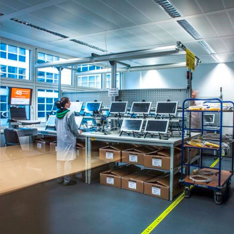 Arbeitsplatz im Alcon WaveLight Standort in Teltow, Deutschland, mit mehreren diagnostischen Geräten in Montage und Test.