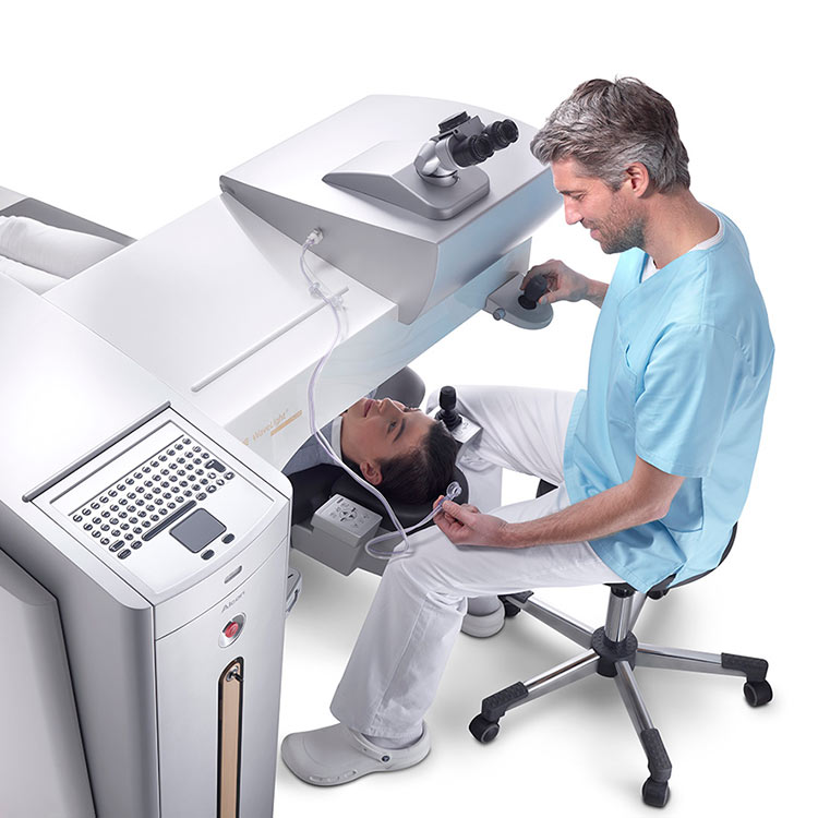 Chirurg bedient den WaveLight FS200 Femtosekundenlaser bei einer Patientin, die in Position liegt.