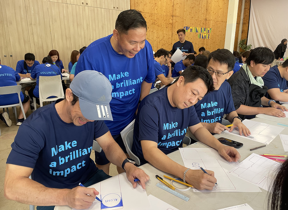 Employees in blue t-shirts filling out forms