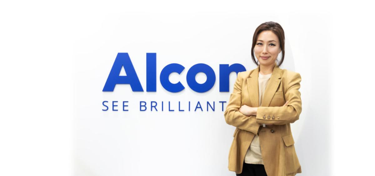 Nicole Bang standing next to Alcon sign