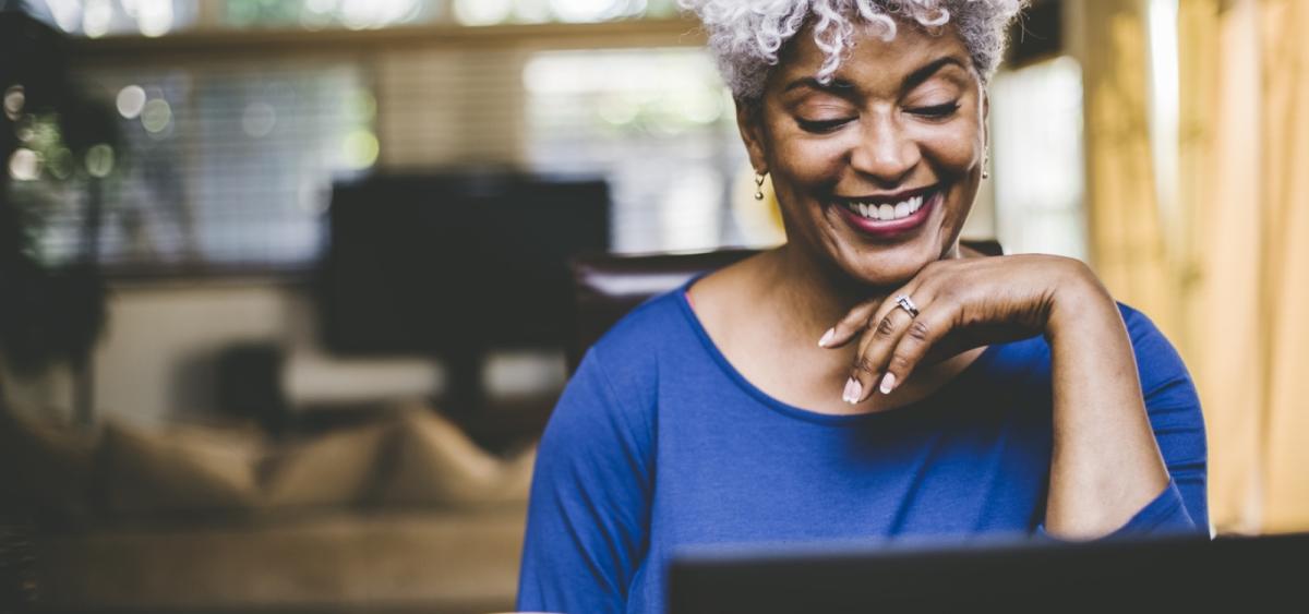 Woman smiling and working on laptop computer