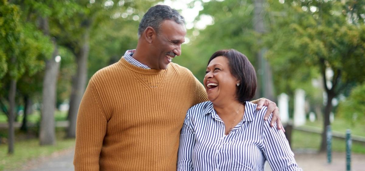 mature man and woman walking in park and smiling