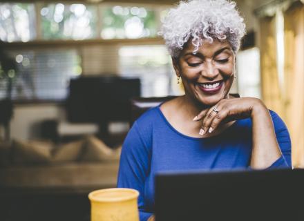 Woman smiling and working on laptop computer