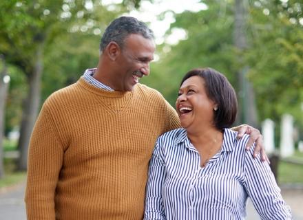 mature man and woman walking in park and smiling