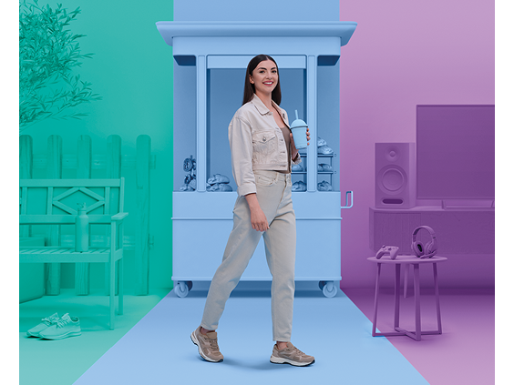 Smiling woman walking with a drink in hand, surrounded by three themed zones: a teal outdoor patio area with a bench and sneakers, a blue kitchen cart with cookware, and a purple entertainment area with a TV, headphones, and speakers