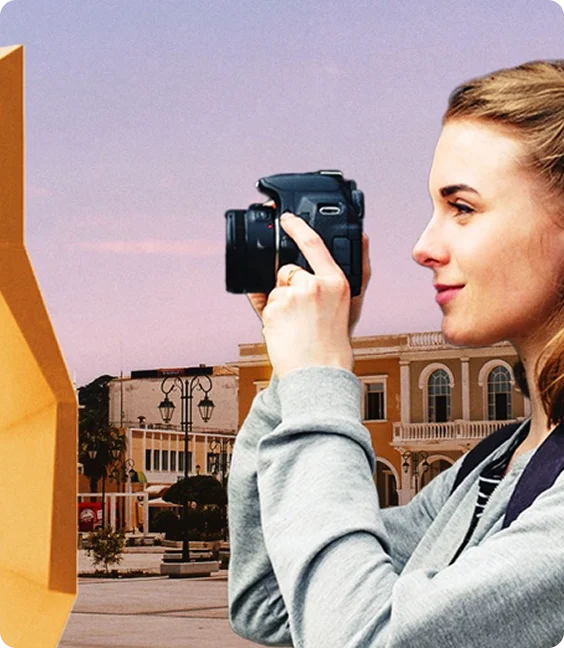 Woman photographing city architecture at sunset