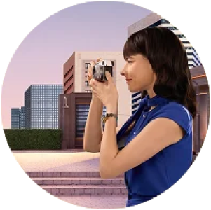 Woman outdoors taking a photo with a camera in front of modern city buildings